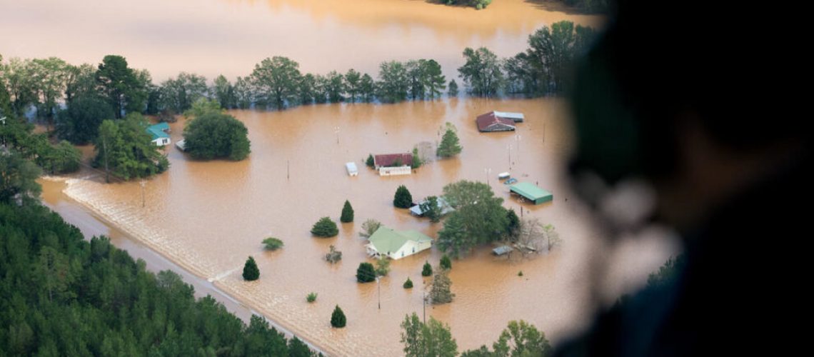 An official looks out a Blackhawk Helicopter at homes surrounded by flood waters due to Hurricane Florence in Conway, South Carolina. Many rivers in the Carolinas are approaching record flood stages and their levels will continue to rise through the week.